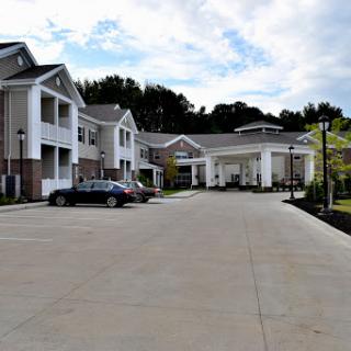 A view of a modern residential apartment complex with a spacious parking lot.