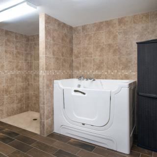 A modern bathroom featuring a walk-in tub and tiled walls.