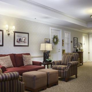A cozy living room with a sofa, armchair, and elegant decor.
