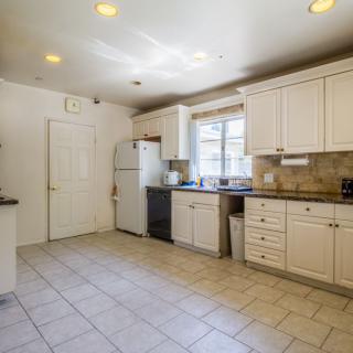 Spacious kitchen with white cabinets and modern appliances.