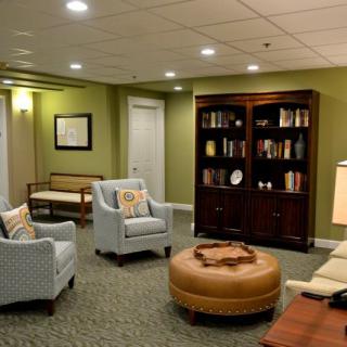 A cozy living room with comfortable seating and a bookshelf filled with books.