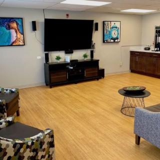 A modern living room with a large television and abstract artwork.