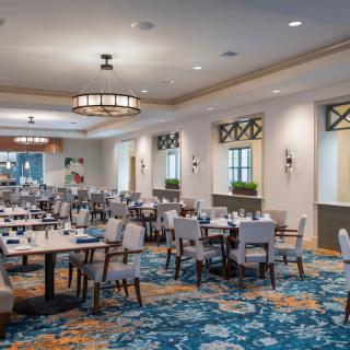 Spacious and elegantly designed restaurant dining area with neatly arranged tables and chairs.