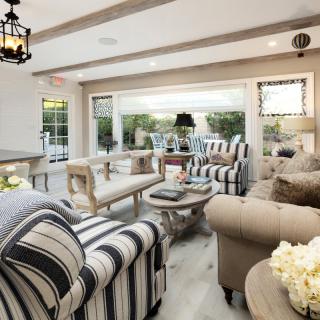 A cozy living room with striped furniture and modern decor, filled with natural light.