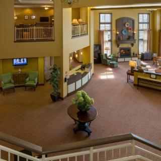 A spacious hotel lobby with a reception desk, seating area, and elegant decor.