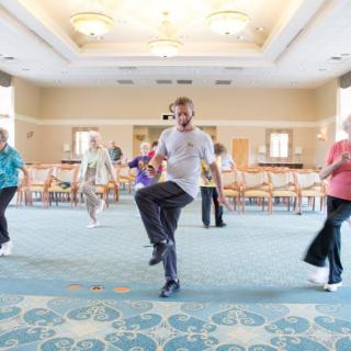 A group of senior individuals participating in a fitness class indoors.