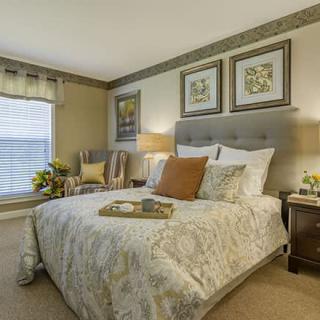 A cozy and well-decorated bedroom with a large bed and elegant artwork.