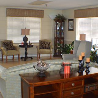 A cozy living room featuring comfortable seating, decorative elements, and abundant natural light.
