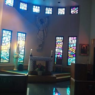 Interior view of a church featuring beautiful stained glass windows and an altar.