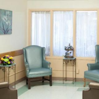 A well-arranged waiting room with two chairs, side tables, and decorative artwork.