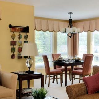 A cozy living and dining space with elegant furnishings and decor, featuring a chandelier above the dining table.