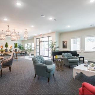 A modern, well-lit lounge area featuring comfortable seating and elegant chandeliers.