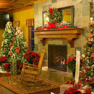 A beautifully decorated room for Christmas featuring a warm fireplace, festive trees, and vibrant holiday decorations.