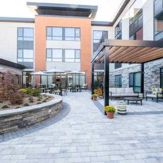A modern building with a well-designed courtyard featuring outdoor seating and landscaping.
