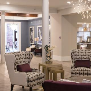 Elegant living room with patterned armchairs and a chandelier.