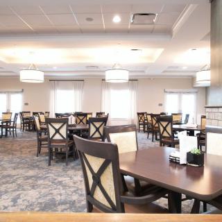 An empty restaurant dining area with neatly arranged tables and chairs.
