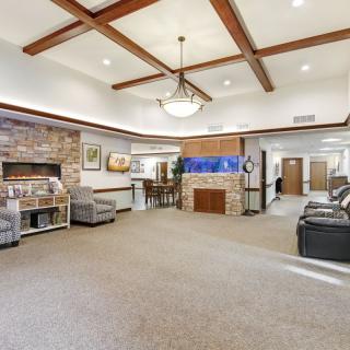 A spacious lobby area featuring comfortable seating, an aquarium, and wooden ceiling beams.