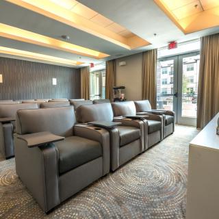 A luxurious theater room with plush seating arrangements facing a screen.