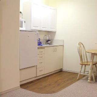 A cozy kitchen and dining area with a wooden table, chairs, and built-in cabinetry.