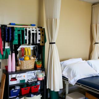 An organized therapy room featuring various exercise tools and equipment for rehabilitation.
