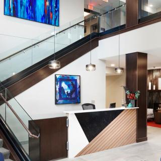 A modern office reception area with contemporary artwork and a stylish staircase.