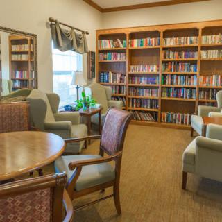 A cozy library reading area with bookshelves filled with books and comfortable seating.