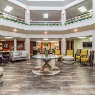 A spacious and modern lobby with comfortable seating and a central decorative table.