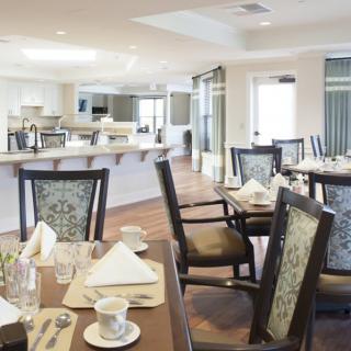 A modern dining area with neatly arranged tables and chairs, set up for a meal.