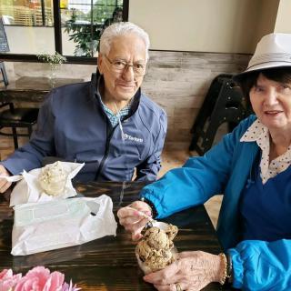 An elderly couple enjoying a meal together at a cafe.