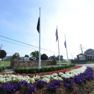 A well-maintained floral display with flags in the background, creating a vibrant outdoor space.