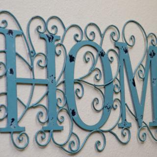 Ornate blue metal wall art spelling 'HOME'.