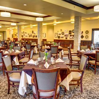 An elegant restaurant dining room with neatly arranged tables and chairs.