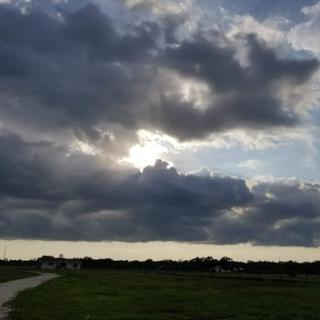 A serene moment captured as sunlight breaks through the clouds over a vast landscape.