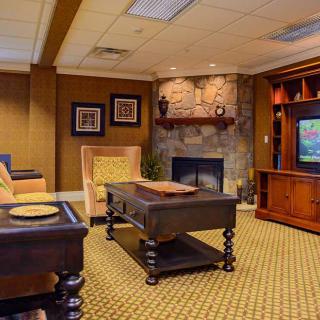 A cozy living room with a fireplace and television, featuring comfortable seating and warm decor.