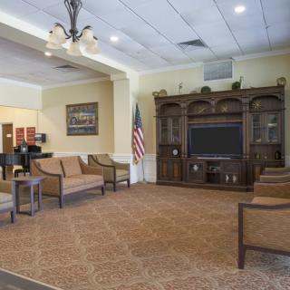 A spacious living room with comfortable seating, a large television, and elegant decor.