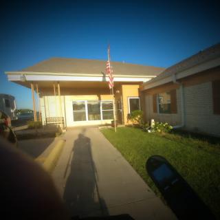 A sunny day outside a building with an American flag and a pathway.