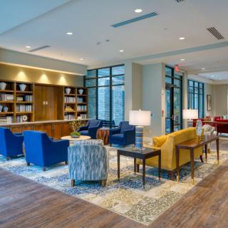 A modern lobby with comfortable seating and bookshelves.