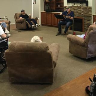 A group of people having a discussion in a cozy, indoor seating area.