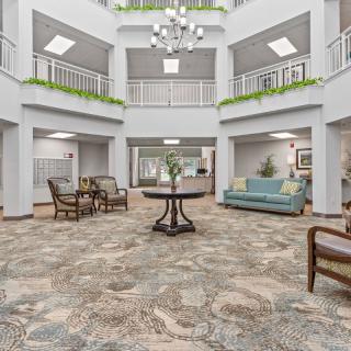 A spacious and elegantly decorated lobby with seating areas and a chandelier.