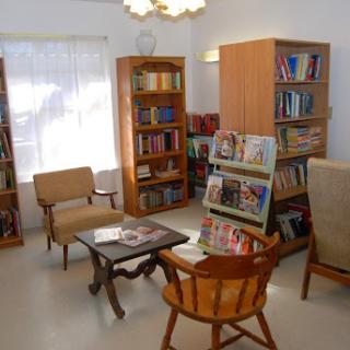 A cozy reading area featuring wooden bookshelves filled with books, comfortable seating, and a warm atmosphere.