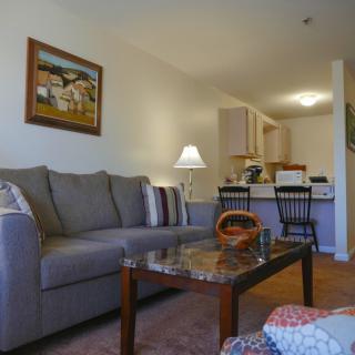 A cozy living room featuring a comfortable sofa, coffee table, and warm lighting.