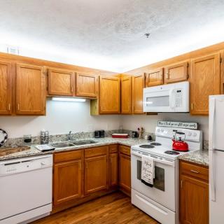 A cozy kitchen with wooden cabinets and modern appliances.