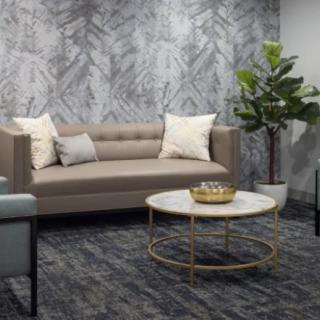 A modern living room with a stylish sofa, marble-top coffee table, and decorative plants.
