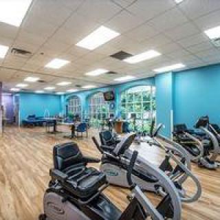 A spacious and well-lit gym with exercise bikes and various fitness equipment.