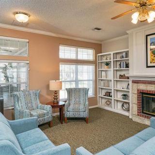 A cozy living room featuring comfortable blue seating, a fireplace, and an organized bookshelf.