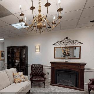 A cozy living room with a chandelier, fireplace, and comfortable seating.