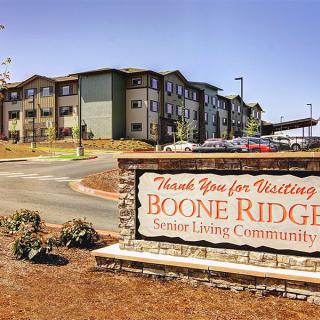 Entrance sign for Boone Ridge Senior Living Community with residential buildings in the background.