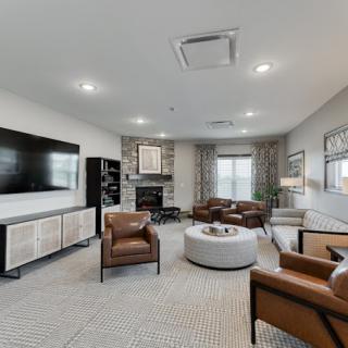 A modern living room featuring comfortable seating, a large television, and stylish decor.