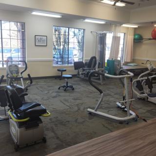A well-lit gym room equipped with various exercise machines and workout equipment.