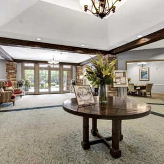 A spacious and elegantly decorated lobby area with a central table displaying flowers.